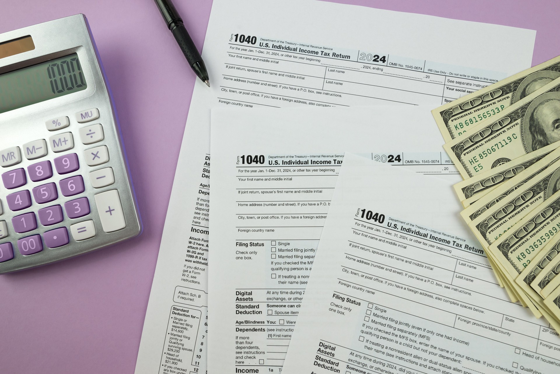1040 tax form 2024 . Tax return forms 1040 with office supplies and dollar bills. Time to pay taxes.