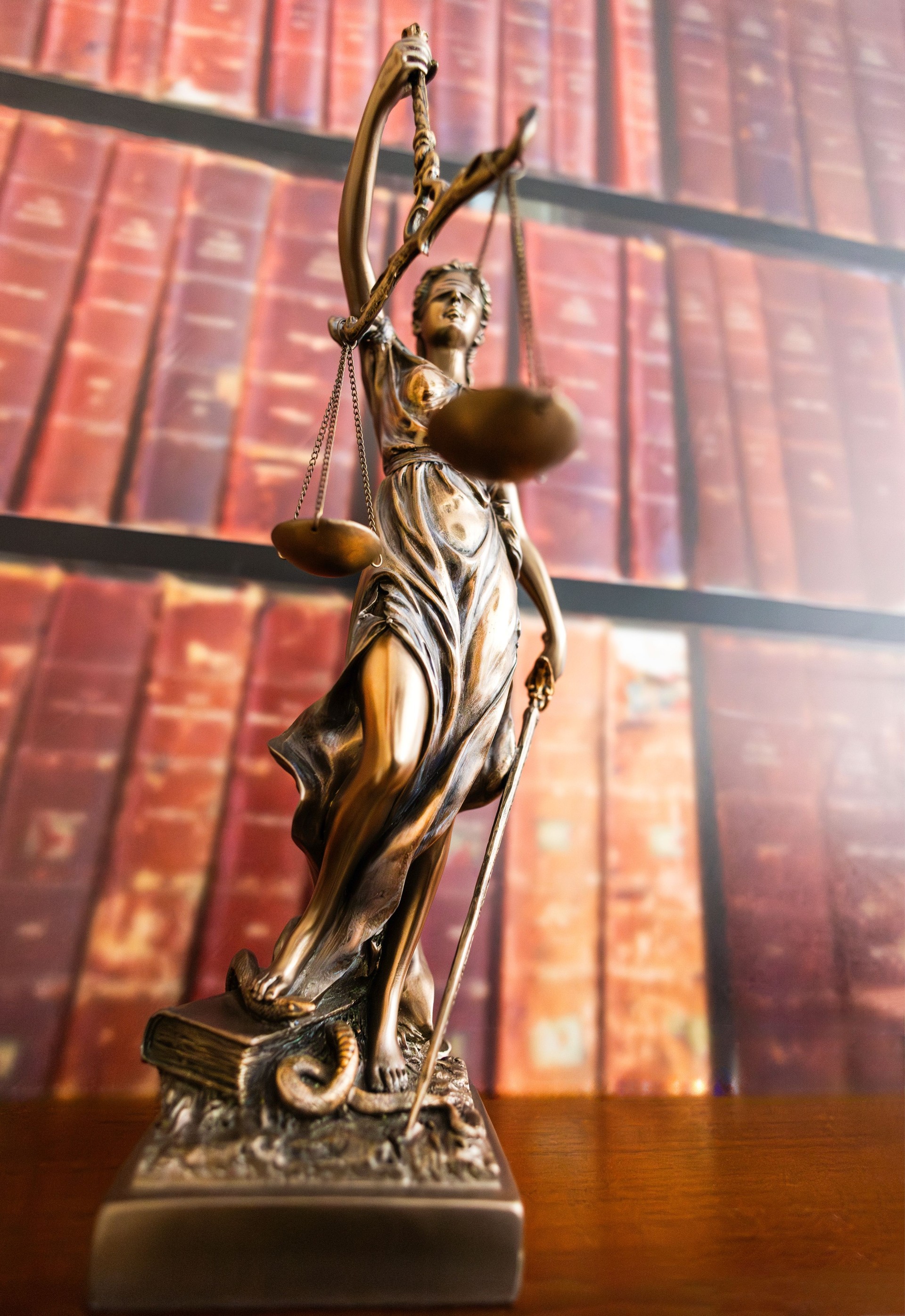 Statue of justice in front of law books